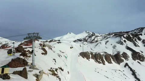 Ski resort cableway cabins move fast against snowy mountains Stock Footage 130634006