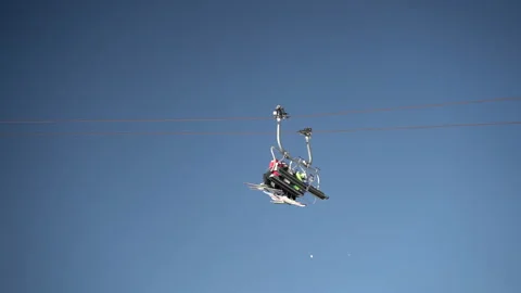 Ski resort chairlift cableway elevator passing each other against bright Stock Footage 231657656