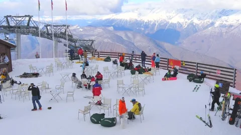 Ski resort Krasnaya Polyana. Bright Skiers, snowboarders go skiing. Aerial Stock Footage 148862453