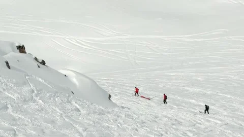 Ski resort mountain rescue team member skiing downhill pulling orange rescu.. Stock Footage 342929765