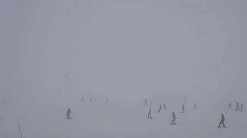 Ski slope in fog. Cloudy, poor visibility. Skiers ski in bad weather. Stock Footage 199234497