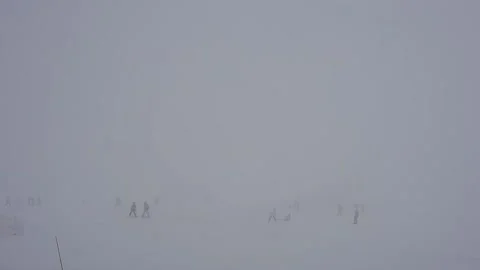 Ski slope in fog. Cloudy, poor visibility. Skiers ski in bad weather. Stock Footage 199234510