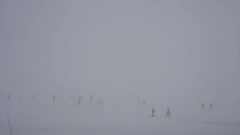 Ski slope in fog. Cloudy, poor visibility. Skiers ski in bad weather. Stock Footage 199234516