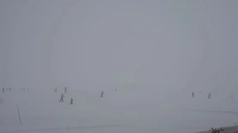 Ski slope in fog. Cloudy, poor visibility. Skiers ski in bad weather.  Stock Footage 199234524