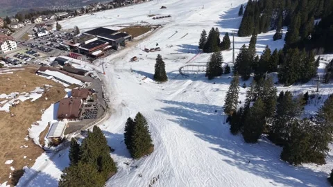 Ski slope with a mountain resort in view and very few skiers 스톡 동영상 331096645