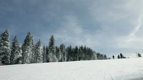 Ski slope with people skiing in winter idyll Stock Footage