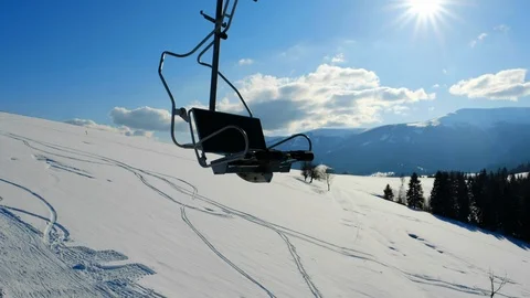 Ski slope with snow surface and skiers lifting on ski-lift in mountains. Stock Footage 112683507