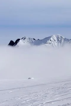 Ski slope with trace from skis and snowboards and snowy high mountains Stock Photos