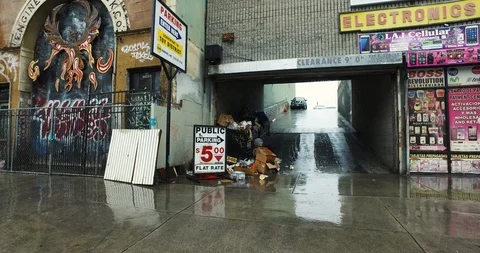 Skid Row Homeless Man Going Through Trash in Rain Stock Footage 101316627