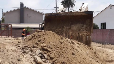 Skid Steer dumping dirt at a construction yard Stock-Footage 228794767