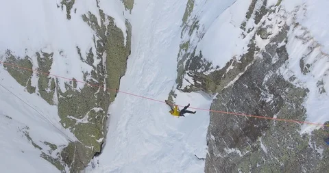 Skier balancing on the rope between two mountains Stock Footage 108637787