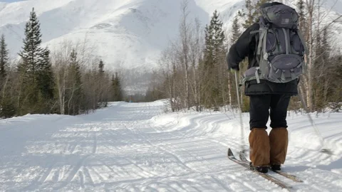Skier beginner with large backpack crosses snowy track Video stock 108851861