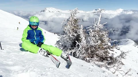 Skier boy sit on top of the mountain in clouds lift hands up Video stock 204139869