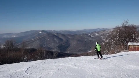 Skier Carving Down the Snowy Slopes on the Mountain With Clear Skies Snowy Trees Video stock 71752813