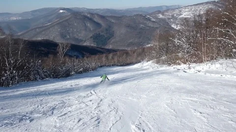 Skier Carving Down the Snowy Slopes on the Mountain With Clear Skies Snowy Trees 動画素材 71753151