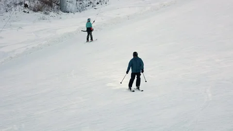 Skier Descends A Snowy Slope While Another Uses A Surface Lift In The Background Stock Footage 315766935