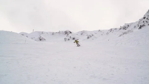 Skier dressed up in bright clothes makes snow waves and throws snow on the Vidéo 101788168