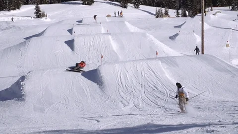 Skier drops in to hit park jump Stock Footage