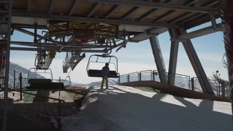 Skier gets off a chair lift, cable lift, ski lift in slow-motion Stock Footage
