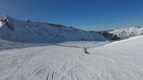 Skier in a green jacket is skiing down a snow covered slope. Wide angle view Stock Footage 330384257