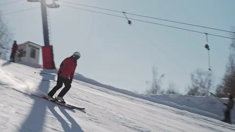 Skier in a helmet goes down the ski slope on a sunny day at a ski resort Stock Footage 221817994