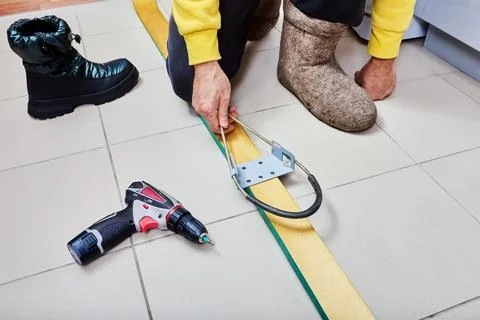 Skier installs spring cable bindings on wooden skis. Stock Photos