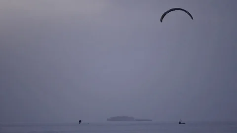Skier on kite making various tricks, flying over the frozen lake, 4k Video stock 71321426
