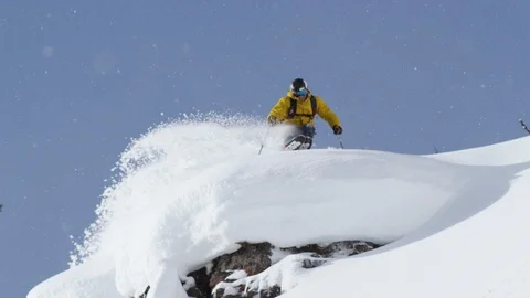 Skier making turns while skiing down from high snowy mountain cliff Stock Footage 116784646