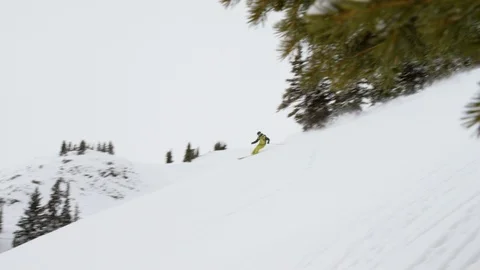 Skier making turns while skiing on snowy mountain slope Stock Footage 116785586