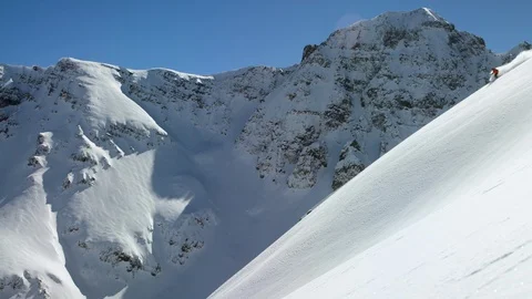 Skier making turns while skiing on snowy mountain slope Stock Footage 116785601