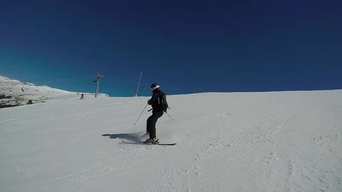Skier in the mountains in winter rolls down a fast twisting downhill track. Video stock 75566577