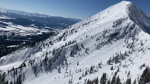 A skier paragliding down a steep face in the Bridger Mountains Stock Footage 236411363