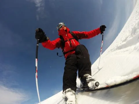 Skier performs a high speed turn on a ski slope. Stock Photos