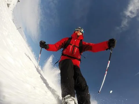 Skier performs a high speed turn on a ski slope. Stock Photos