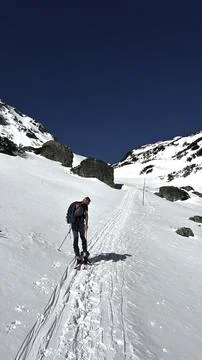 A skier in the process of climbing a high-mountain section Stock Photos
