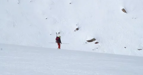 Skier in a red suit goes down the mountain slope slowly. Stock Footage 145111625