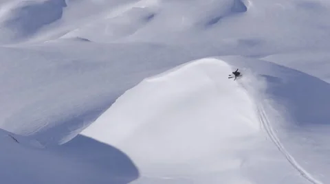 Skier rides down an untracked mountain and does a turn on a hill Video stock 56143545