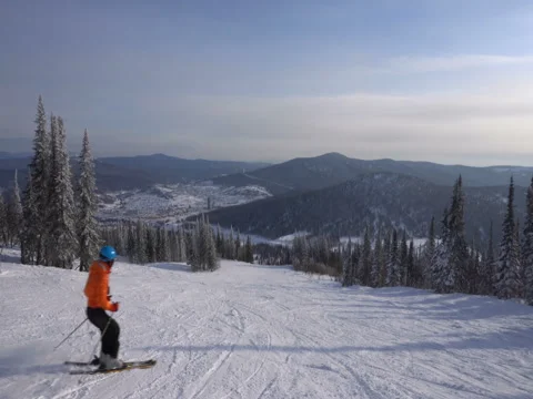 Skier is riding down fast upon ski track on the background of winter moun Stock Footage 71595655