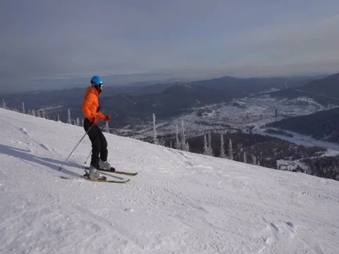 Skier is riding down slowly upon winter ski track on the background of mo Vídeos de archivo 71593248