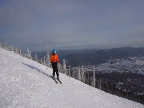 Skier is riding down slowly upon ski track on the background of winter mo Stock Footage 71593791