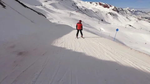 Skier running down the slope slowly in a ski resort alone. Winter sport Stock Footage 143018833