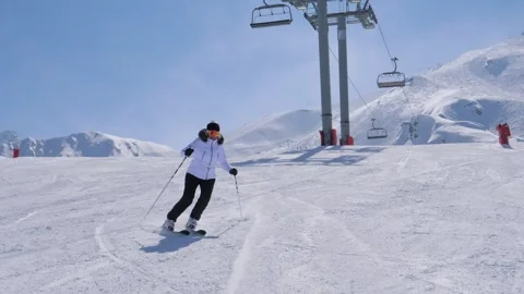 Skier skiing down slalom on ski slope in mountain landscape Stock Footage 320083069