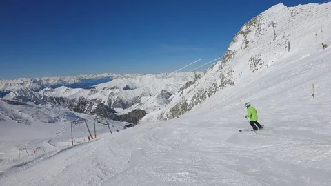 Skier is skiing down a snow covered slope. Sunny  with blue sky Stock Footage 330384310