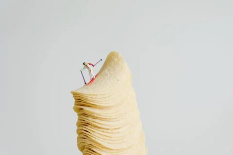 Skier skiing down from stack of potato chips Stock Photos