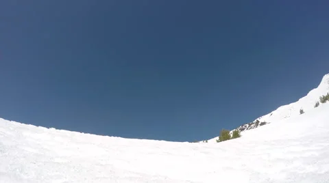 Skier slashing soft spring snow under a blue sky and hot sun Stock Footage 48372681
