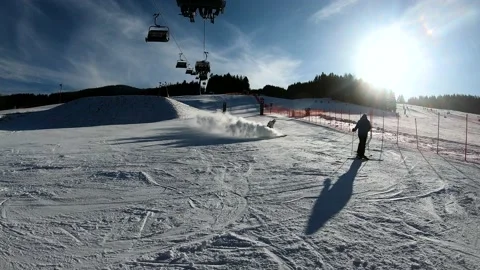 Skier spraying snow into camera in mountain ski resort. Stock Footage 143290744