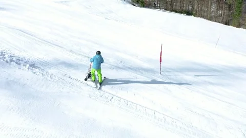 A skier using adaptive equipment glides down snowy slope. Stock Footage 285900544