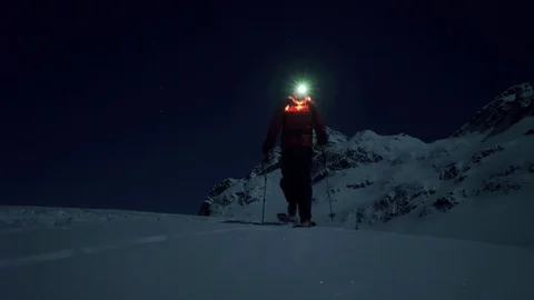 Skier walking in the snow come in front of the camera at night Stock Footage 107094566