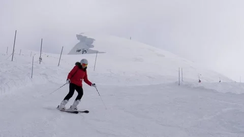 Skier wearing red jacket skiing foggy alpine piste with poles Vídeo Stock 328296269