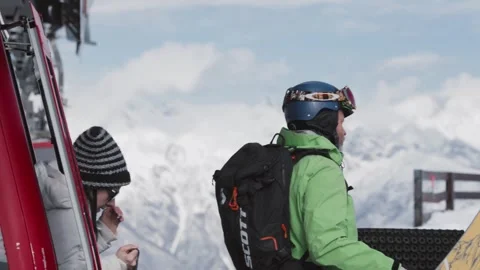 Skiers and snowboarders exit a cable car cabin, ready to hit the slopes with Stock Footage 304502016